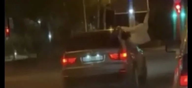 Пассажир по городу, сидя на двери автомобиля Пассажир по городу, сидя на двери автомобиля