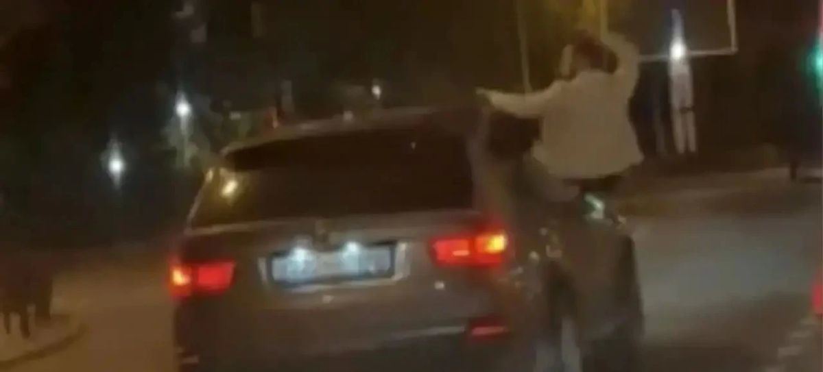Пассажир по городу, сидя на двери автомобиля Пассажир по городу, сидя на двери автомобиля